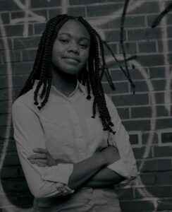 girl leaning on wall greyscale