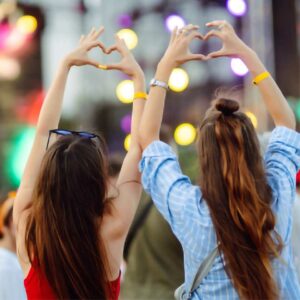 two girls making heart hands